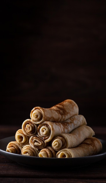 Pancakes rolled up into tubes lie on a slide