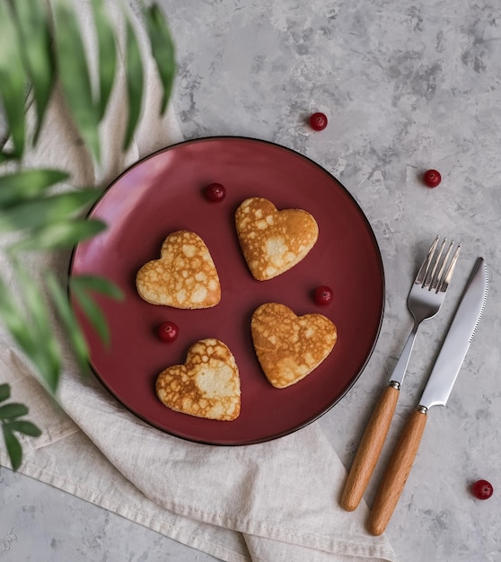 Pancakes in the shape of a heart on gray table Breakfast for lovers