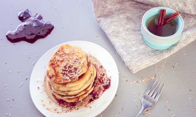 Photo pancakes sprinkled with sesame and tea