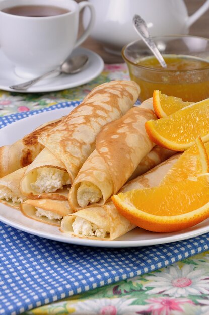 Pancakes stuffed with cottage cheese and oranges for breakfast