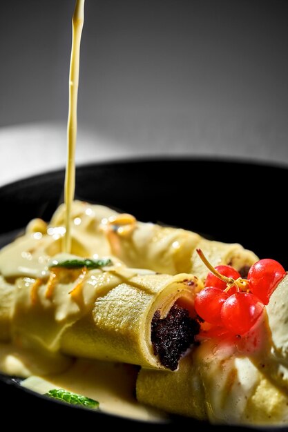 Pancakes stuffed with poppy and ice cream in a plate White tablecloth background Ukrainian Blini