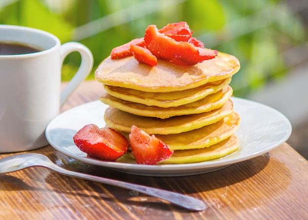 Pancakes tea and strawberry jam for breakfast