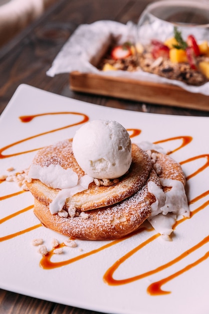 Pancakes topping with a scoop of coconut ice cream, coconut meat.