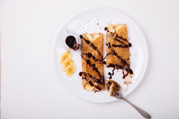 Photo pancakes with banana and chocolate topping