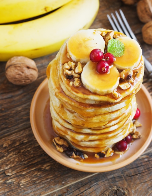 Pancakes con banana, noci e caramello per una colazione.