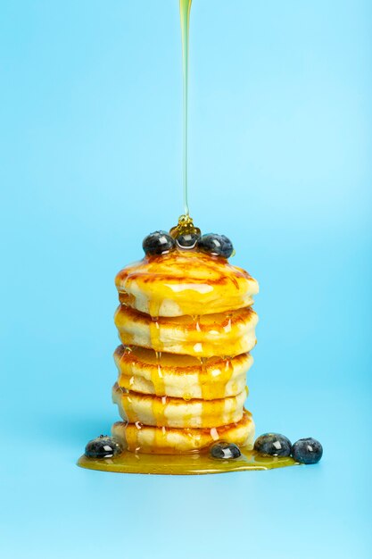 Foto frittelle con frutti di bosco su uno sfondo blu banner lussureggianti deliziose frittelle con mirtilli e sciroppo...