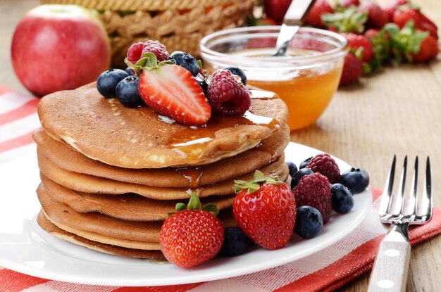 Pancakes with berries and honey closeup