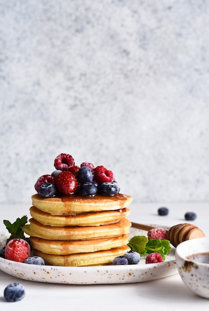 Pancakes with berries and maple syrup for breakfast  