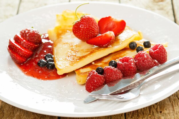 Pancakes with berries and sugar powder