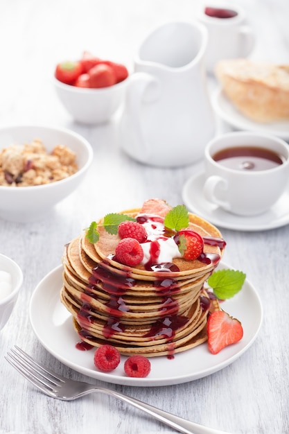 Pancakes with berry and jam for breakfast