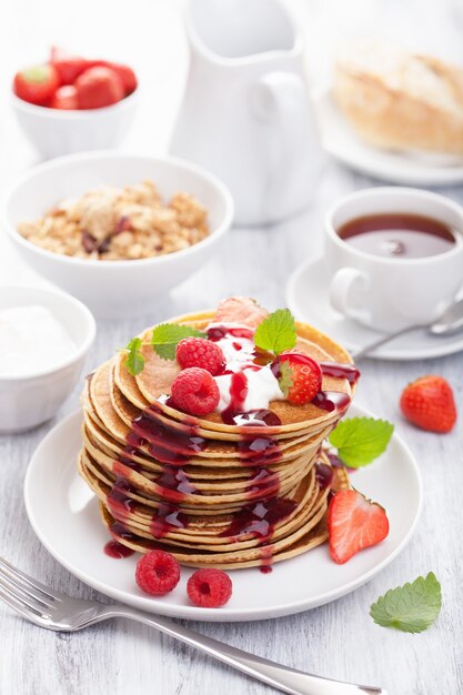 Pancakes with berry and jam for breakfast