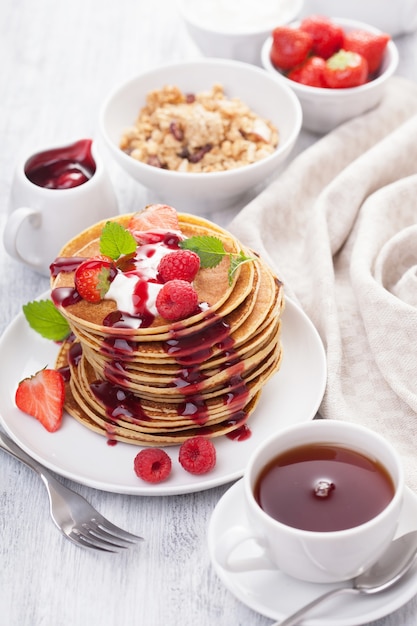 Pancakes with berry and jam for breakfast