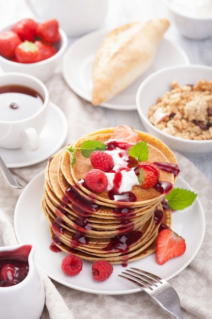 Pancakes with berry and jam for breakfast