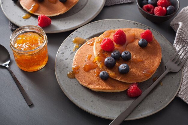 Pancakes with blueberry raspberry honey and jam for breakfast