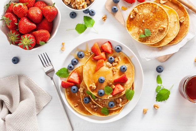 Pancakes with blueberry strawberry honey and nuts for breakfast