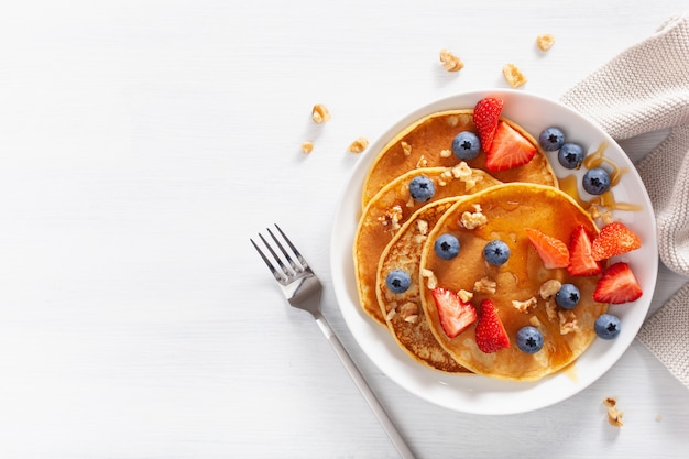 Pancakes with blueberry strawberry honey and nuts for breakfast