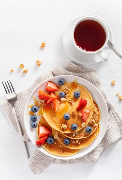 Pancake con miele di fragole ai mirtilli e noci per la colazione