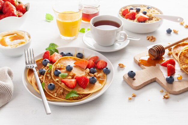 Pancakes with blueberry strawberry honey and quinoa for breakfast