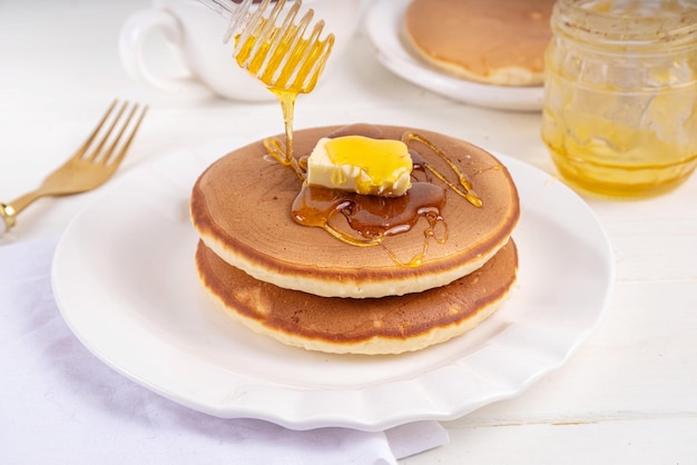 Pancakes with butter and honey or maple syrup drizzles