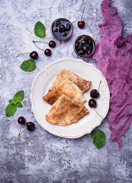 Pancakes with cherry jam and berries