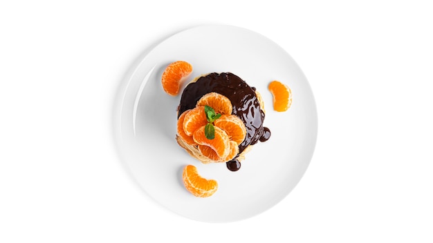 Pancakes with chocolate and tangerines isolated on white.