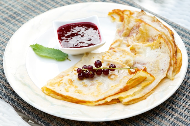 Photo pancakes with currant berries and jam