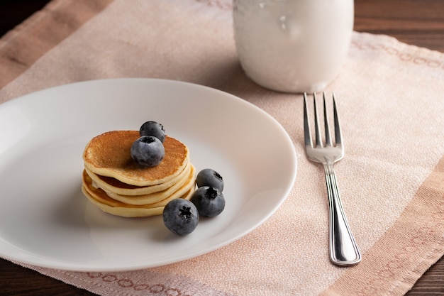 Photo pancakes with fresh blueberries strawberries served on a wooden table healthy morning breakfast