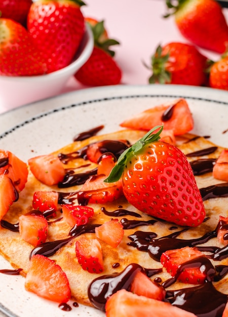 Pancakes with fresh strawberry on a blue wooden background