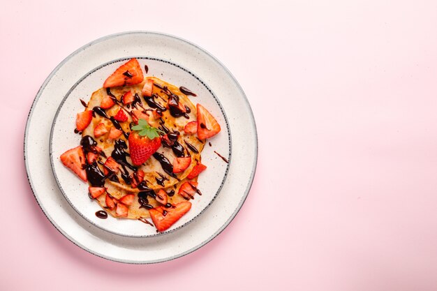 Pancakes with fresh strawberry on a blue wooden background