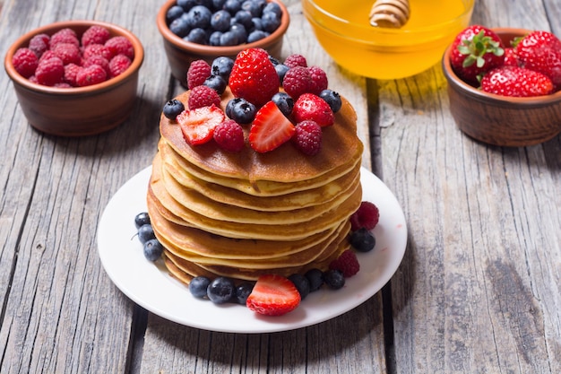 Pancakes with honey berries blueberries raspberry and strawberry