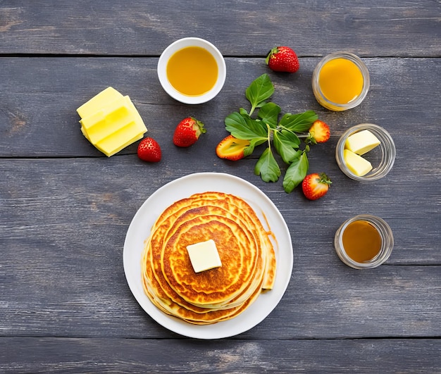 Pancakes with honey and tea on a white plate top view