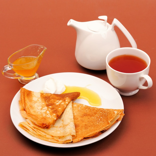 Pancakes with honey and tea.