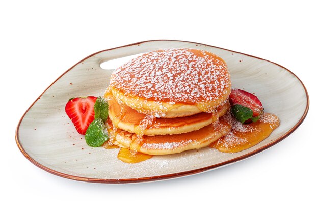 Pancakes with maple syrup on plate isolated on white