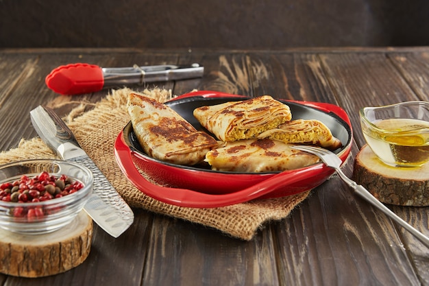 Pancakes with meat on dark wooden background