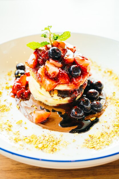 Pancakes with mixed berry fruit in white plate