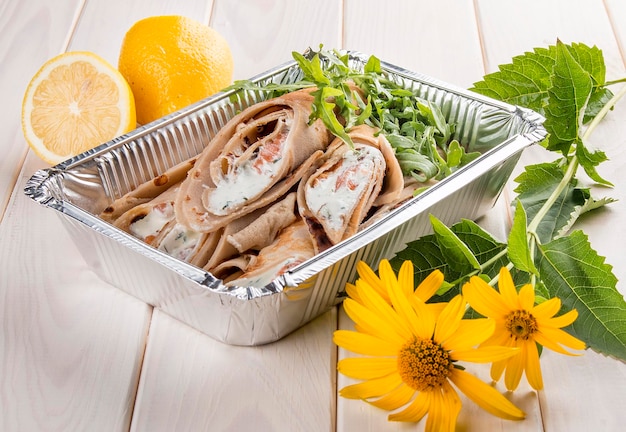 Pancakes with Philadelphia cheese and salmon On a white wooden background Takeaway food Dietary food