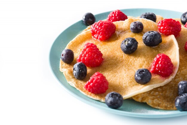 Pancakes with raspberries, blueberries and honey isolated
