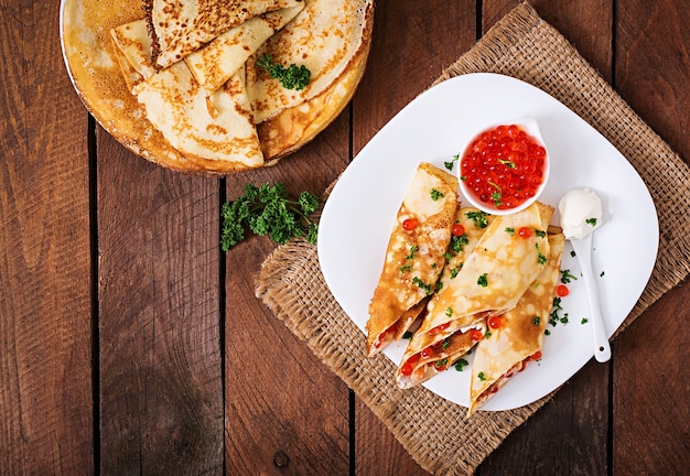 Pancakes with red caviar and cream cheese.