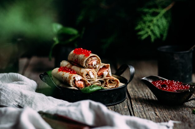 Pancakes with red caviar and salmon in a plate. Maslenitsa holiday