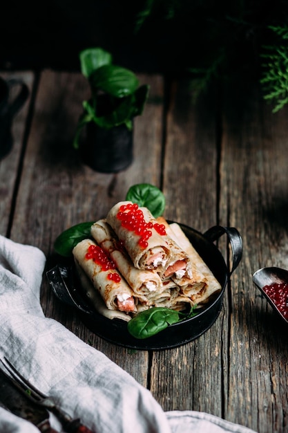 Pancakes with red caviar and salmon in a plate. Maslenitsa holiday