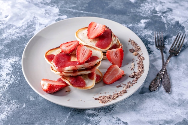 Pancakes with strawberry jam and fresh strawberry slices