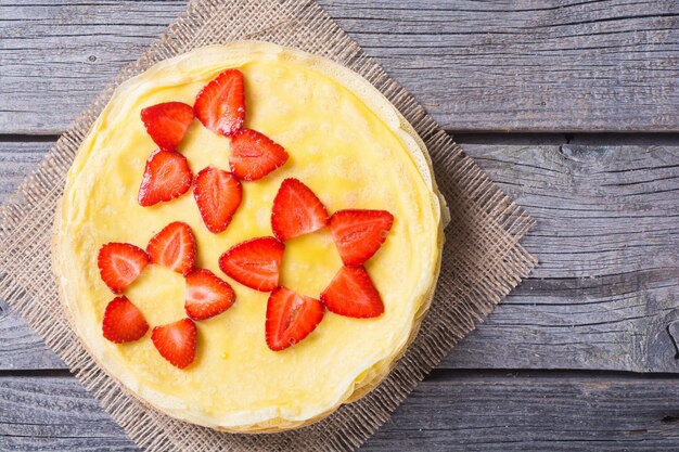 Pancakes with strawberry on rustic wooden background Top view