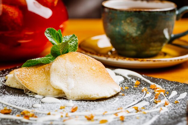 Pancakes with sweet sauce and jam traditional Russian meal on wooden background