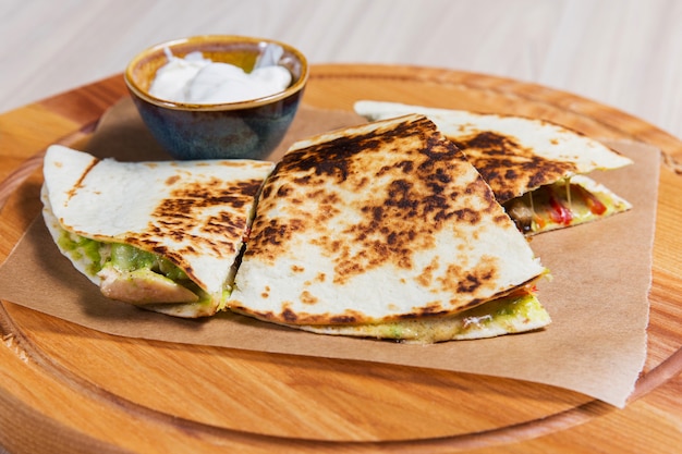 Pancakes with vegetables and white sauce on wooden table in a restaurant. Healthy food