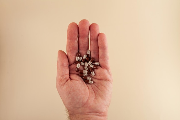 Pancreatin-capsules of Creon-pillen op de palm bejaarde man close-up Pancreatin