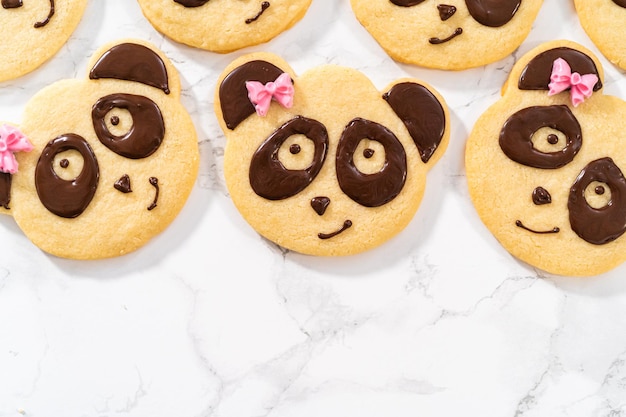 Panda-vormige zandkoekkoekjes met chocoladesuikerglazuur