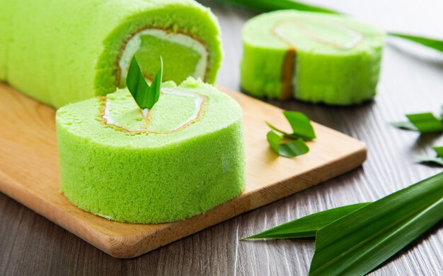 pandan swiss roll cake on wooden table