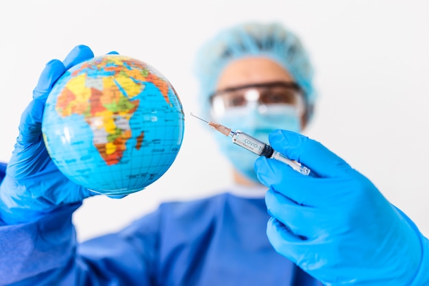 Pandemic concept with scientist injecting vaccine into the earth