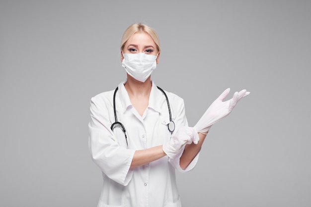코로나 바이러스의 유행성. 청진 기와 흰색 의료 얼굴 마스크에 여자 의사. Covd-19 격리의 개념.