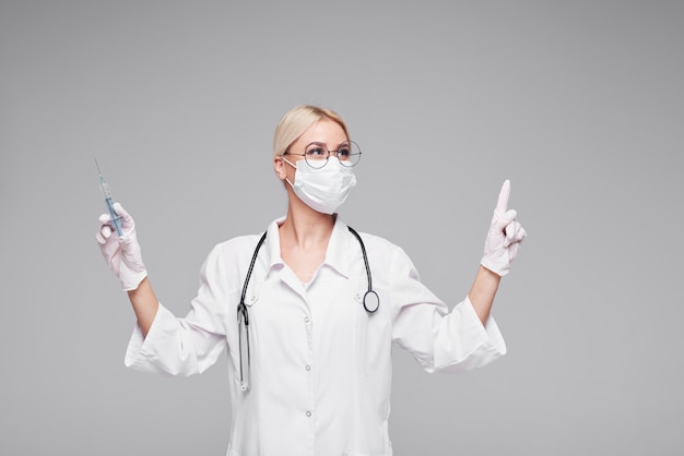 Pandemic of Coronavirus. woman doctor in white medical face mask with stethoscope. Concept of Covd-19 quarantine.